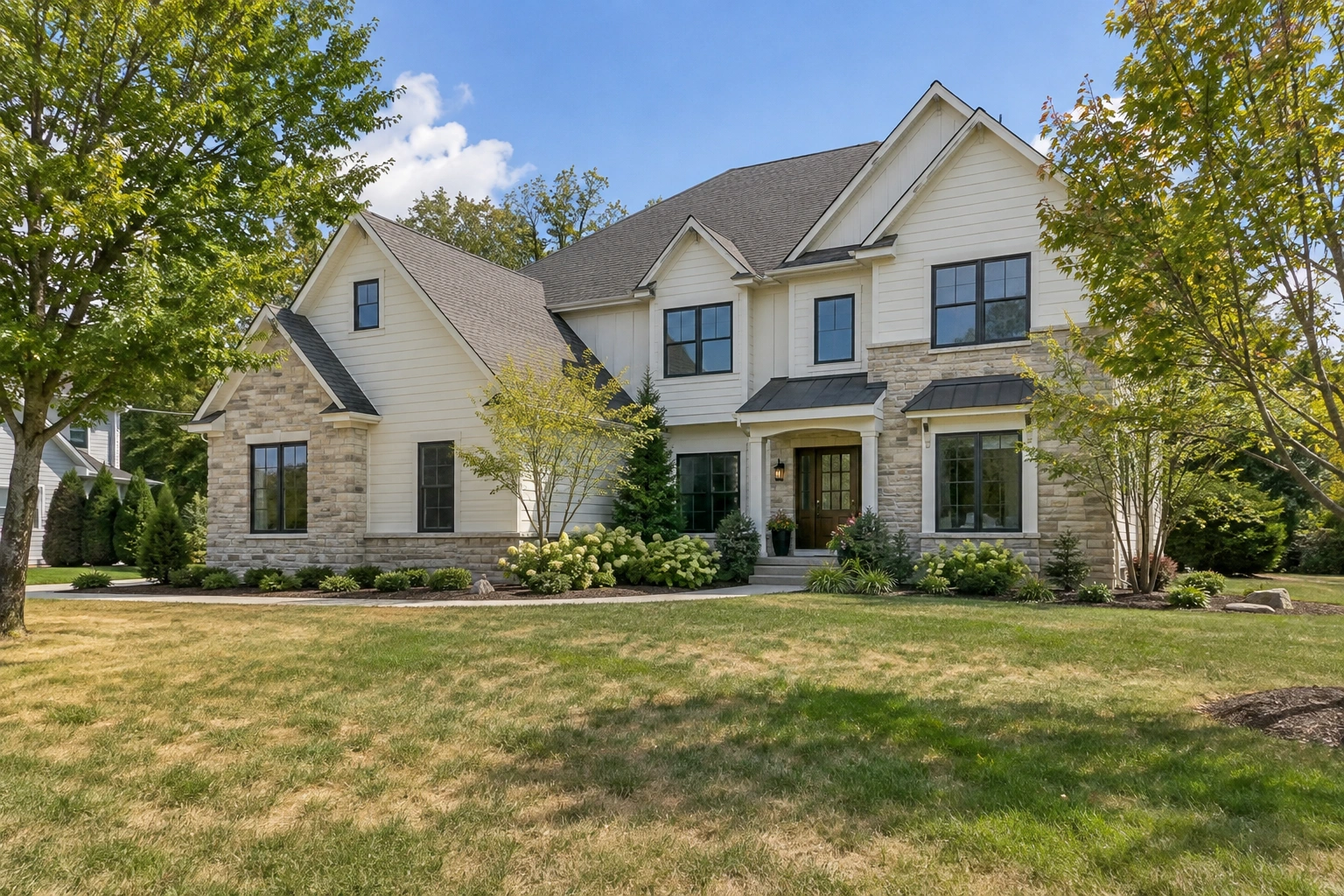 Original daytime house with leafy trees and a patchy lawn